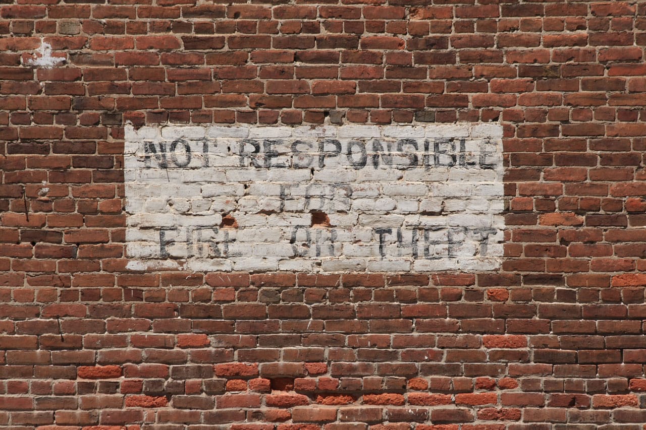 a brick wall with the text: "Not responsible for fire or theft"